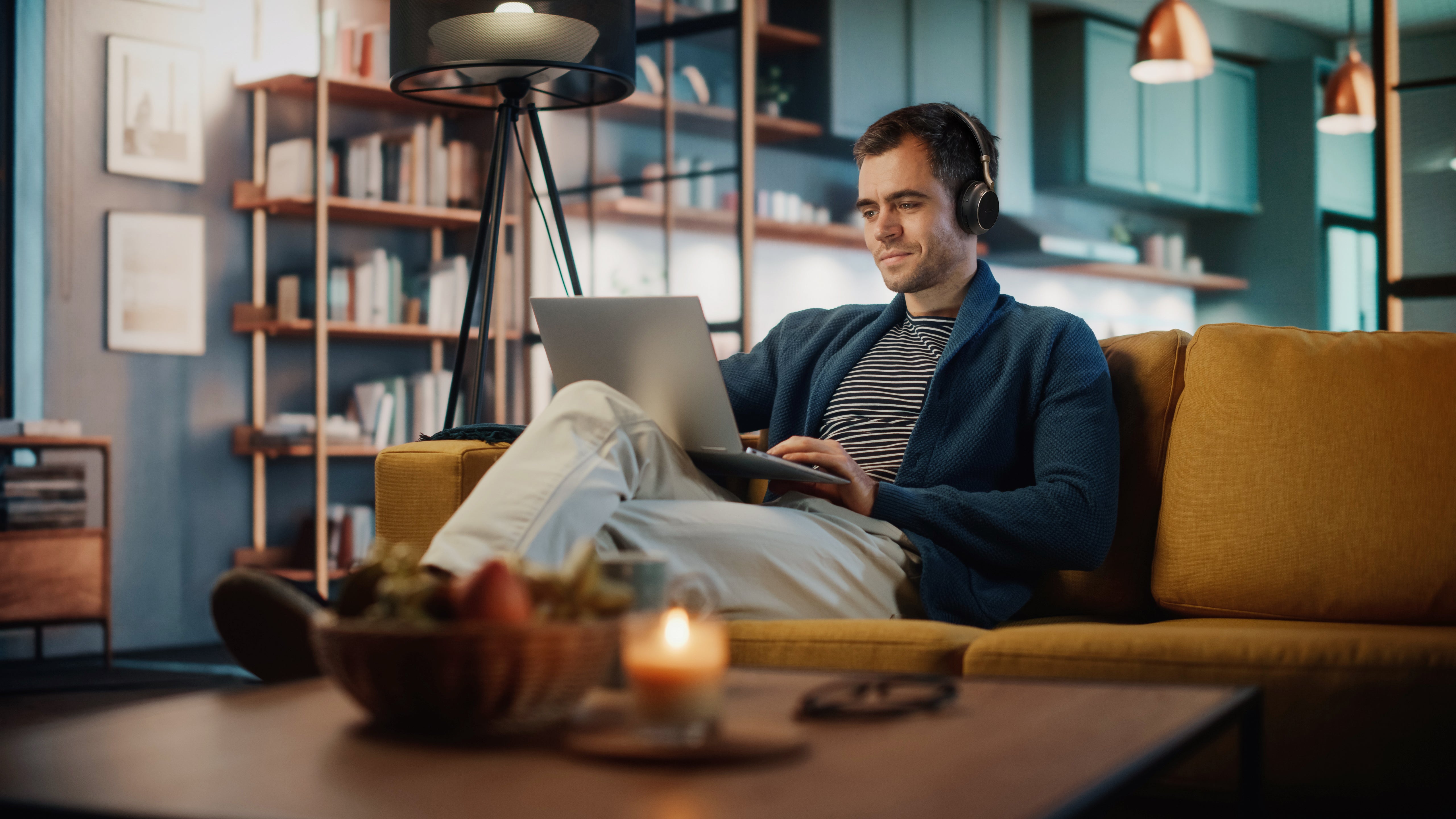 Image of user pairing Yealink BH76 Plus Teams headset with laptop in a home office environment.