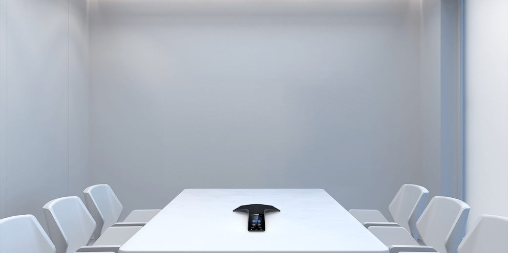 Yealink CP925 HD conference phone sitting on a table in the center of a small, modern meeting room.